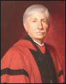 Seated portrait of Timothy Sullivan, dressed in red and black regalia