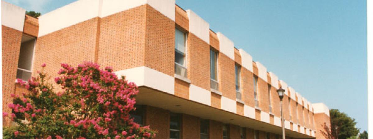 Side view of the two-story brick Rogers building, with Barksdale field on the right