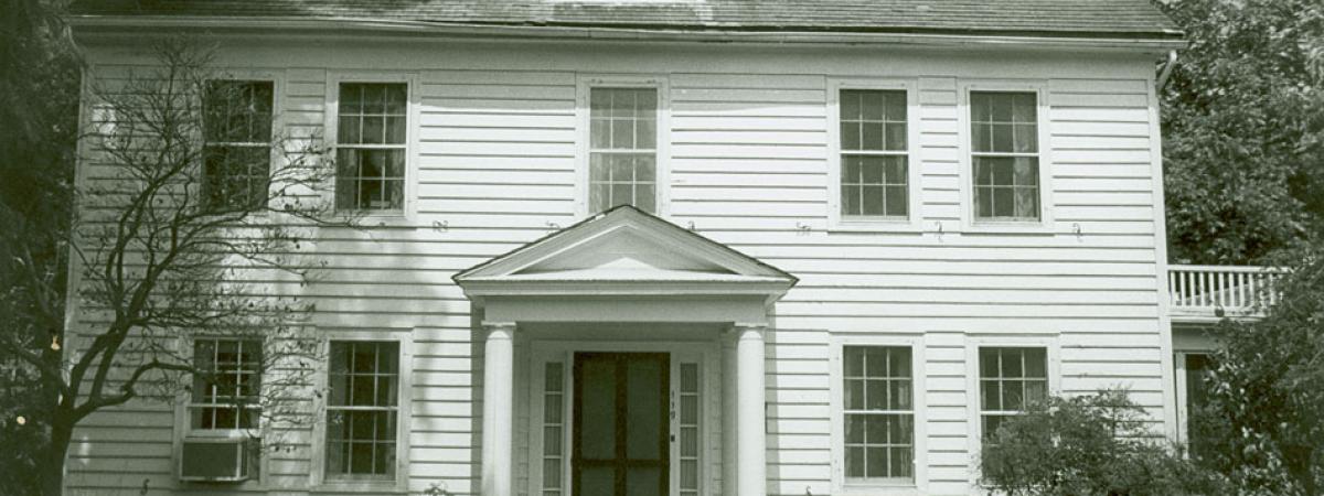 Two story white house with covered entrance and dormer window