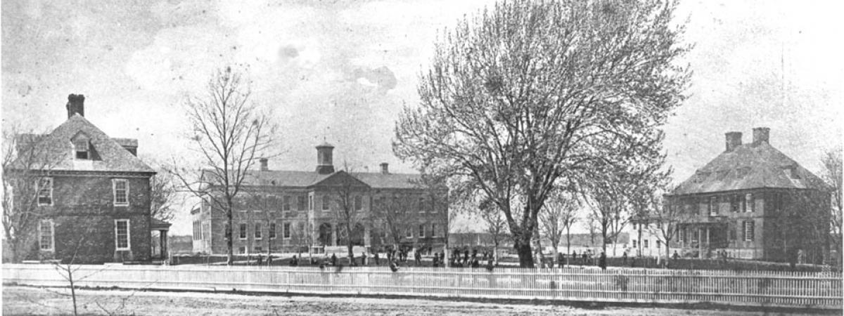 Black and white photo of three brick buildings facing a central yard
