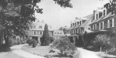 Black and white photo of three of the brick sorority houses surrounding a central garden and walkway 