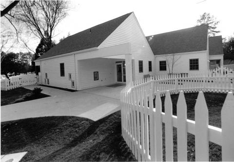 White one-story house with white picket fence