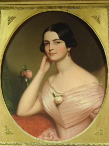 Painted round portrait in a gold frame of Coleman, seated in a pink dress