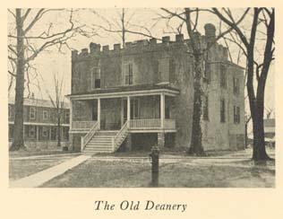 Black and white photo of a two story brick building with covered front porch