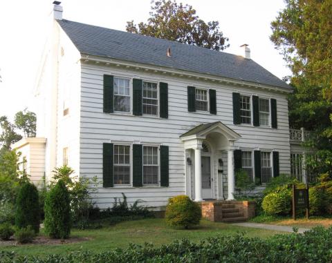 Two story white colonial house with dark shutters