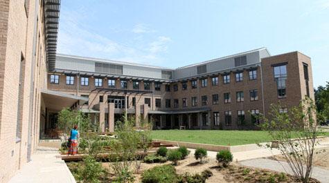 Four story brick and glass School of Education building with central courtyard and garden