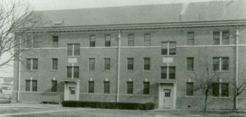 Black and white photo of Tyler Hall, circa 1920, a wide three story brick building