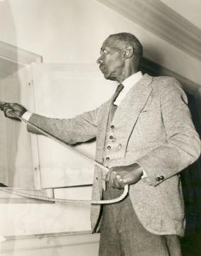 Black and white photo of Henry Billups holding a rope to ring the Wren bell