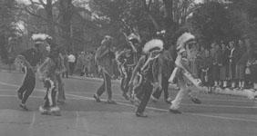 Students dressed as Native Americans walk in the homecoming parade