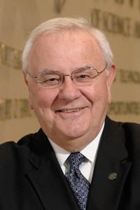 Headshot of Melvyn Schiaville wearing a black suit and tie