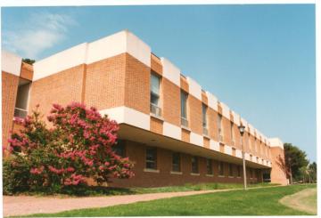 Side view of the two-story brick Rogers building, with Barksdale field on the right