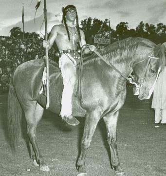 Student dressed in native american garb sitting on a horse