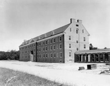 Exterior of Chandler Hall, a four story brick building with arched walkway on side